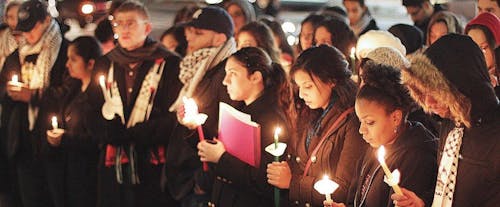 Students light candles and share a moment of silence on the
steps of Brower Commons on the College Avenue campus last night to
remember the lives lost during the Gaza massacres. Several
attendees wore traditional scarves to symbolize solidarity for
Palestine. – Photo by Photo by Scott Tsai | The Daily Targum