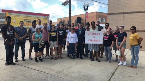 Charlie Kratovil, Rutgers alumnus, editor at New Brunswick Today and mayoral candidate, poses next to his supporters at today's demonstration in support of higher government worker minimum wages.  – Photo by Christian Zapata