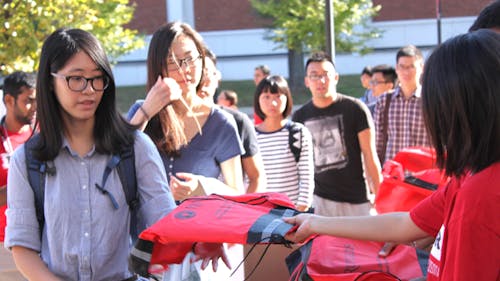 Volunteers hand out packages to international students at this year’s international student orientation. – Photo by Photo by Carissa Sestitio | The Daily Targum
