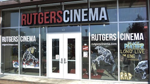 Superhero Black Panther and supervillain Killmonger decorate the tall glass windows at Rutgers Cinema. The movie theater doubles as a lecture hall during the day and Wakanda, the fictional world depicted in “Black Panther,” by night. – Photo by Casey Ambrosio