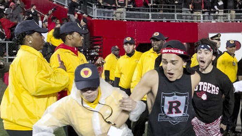 Michael Troglio (center) and Matthew Biscaldi (right), School of Arts and Sciences sophomores, were the first to plow past security guards and rush the football field last Saturday after Rutgers football’s win against Michigan State. – Photo by Photo by Shawn Smith | The Daily Targum
