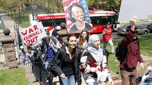 More than 50 students march on April 28 toward the Old Queens building on the College Avenue campus with anti-Rice posters and chants. The protest was meant to demand the cancellation of Condoleezza Rice’s invitation as a commencement speaker for the class of 2014. – Photo by Photo by Dennis Zuraw | The Daily Targum