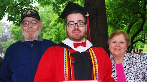Matt Georgi, middle, stands with his parents James Georgi, left, and Patricia Georgi, right, at his graduation ceremony. Matt Georgi planned to run the 41st Annual 18 Mile Run Oct. 13 to raise money for student veterans. – Photo by Courtesy of Charles Tremato