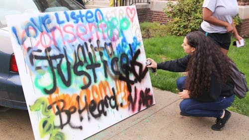 A student spray-paints on a canvas as part of the rally for Rutgers’ “Take Back the Night,” a march dedicated to shattering the silence on sexual violence held Wednesday evening on the Douglass campus. – Photo by Yingjie Hu