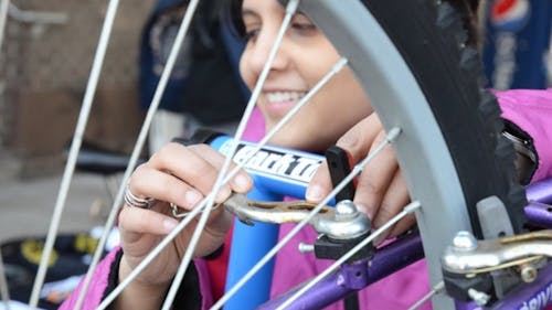 Rewa Marathe, a Graduate Student Association representative, adjusts the brakes on a bike at GSA’s second annual Bike Fair yesterday on the College Avenue campus. – Photo by Paul Solin